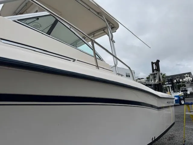 Slide: The Image of 1992 Grady-White Explorer 244 boat with Yamaha engine, docked under cloudy skies. - 4