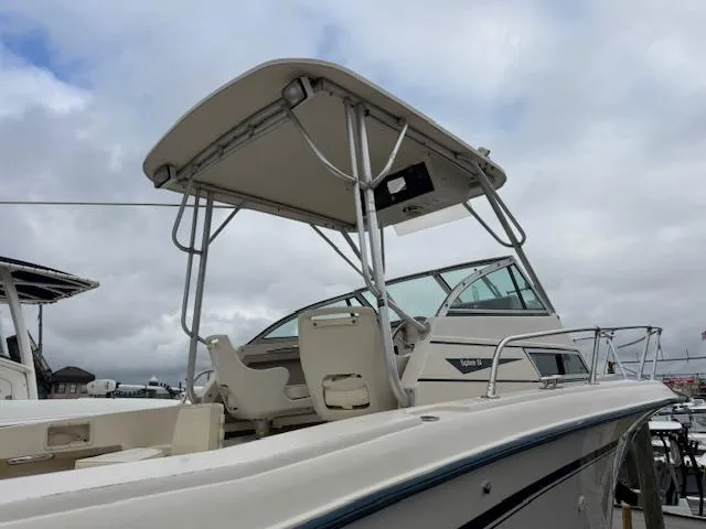 Slide: The Image of 1992 Grady-White Explorer 244 boat with canopy, docked under cloudy skies. - 7
