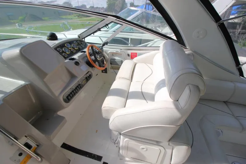 Slide: The Image of 2001 Cruisers Yachts 3470 Express cockpit with white seating and steering wheel. - 11