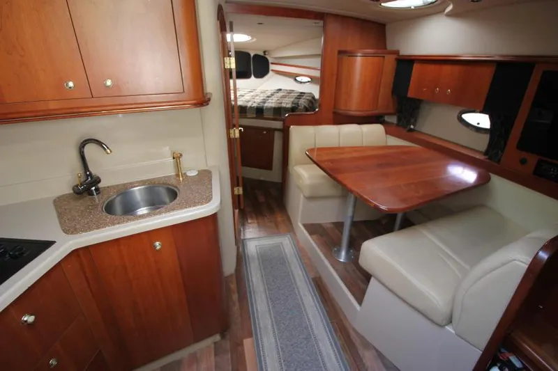 Slide: The Image of 2001 Cruisers Yachts 3470 Express interior with kitchenette, dining area, and sleeping quarters. - 15