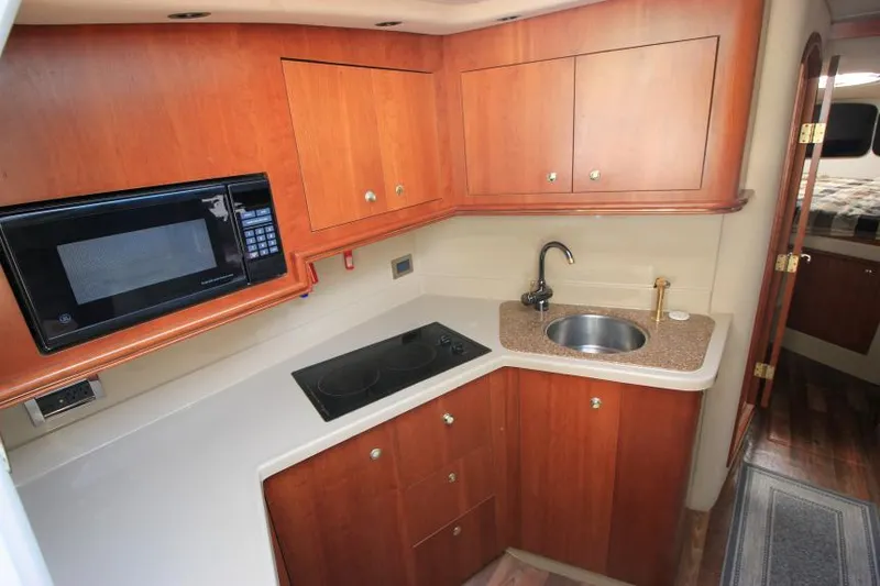 Slide: The Image of 2001 Cruisers Yachts 3470 Express kitchen with microwave, stove, and sink. - 16