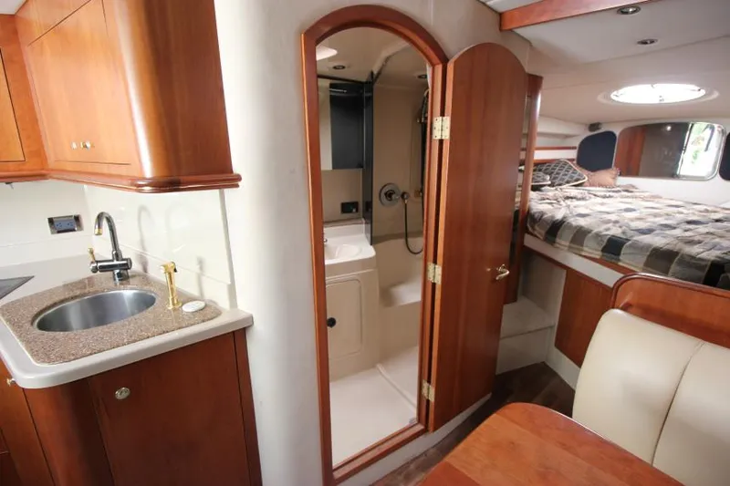 Slide: The Image of Interior of 2001 Cruisers Yachts 3470 Express, featuring kitchen, bathroom, and bedroom. - 21