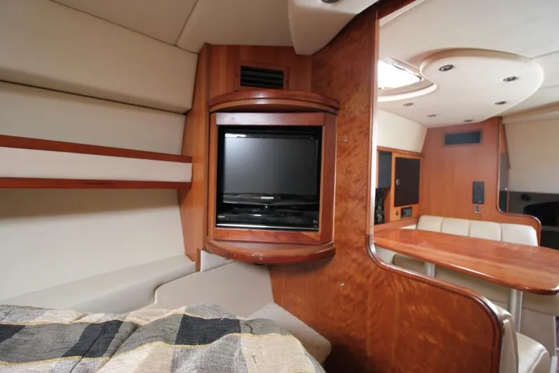 Slide: The Image of 2001 Cruisers Yachts 3470 Express interior with TV, wood paneling, and seating area. - 26