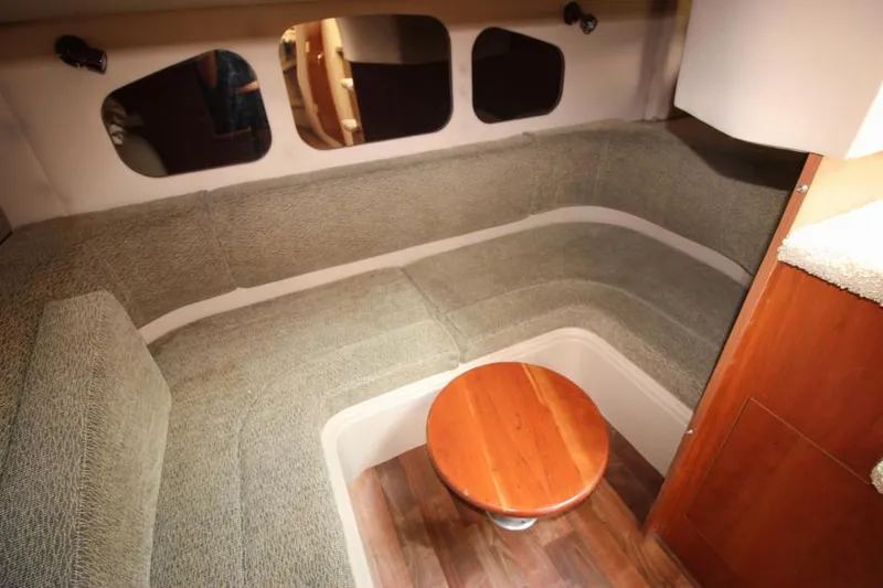 Slide: The Image of 2001 Cruisers Yachts 3470 Express interior with cozy seating and wooden table. - 27