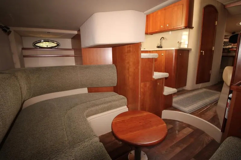 Slide: The Image of Interior of 2001 Cruisers Yachts 3470 Express with cozy seating and wooden cabinetry. - 28