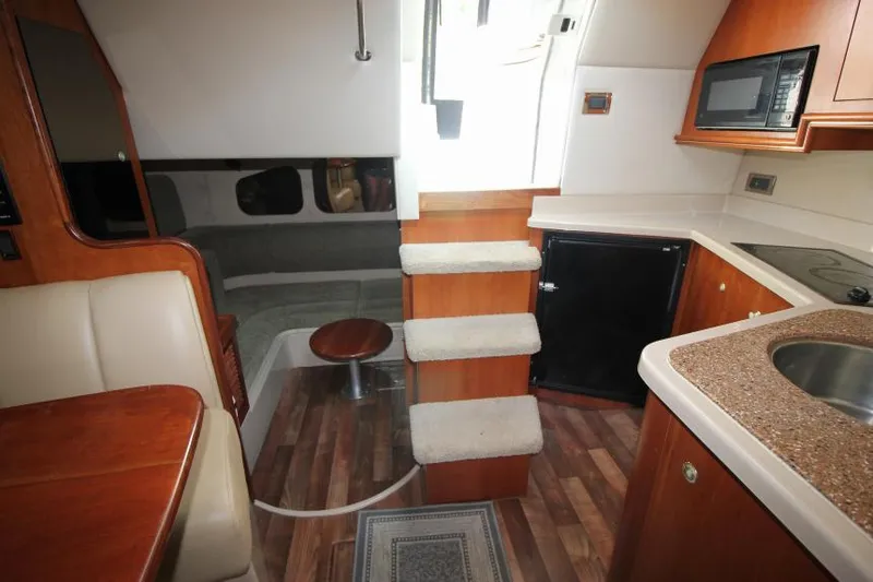 Slide: The Image of Interior of 2001 Cruisers Yachts 3470 Express with kitchenette, stairs, and seating area. - 29