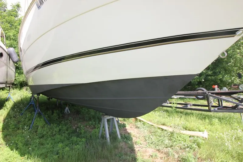 Slide: The Image of 2001 Cruisers Yachts 3470 Express boat on stands, side view, outdoors. - 3