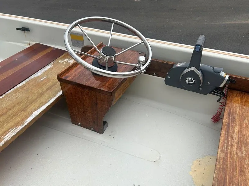 Slide: The Image of 1983 Boston Whaler Sport boat interior with wooden steering console and control lever. - 13