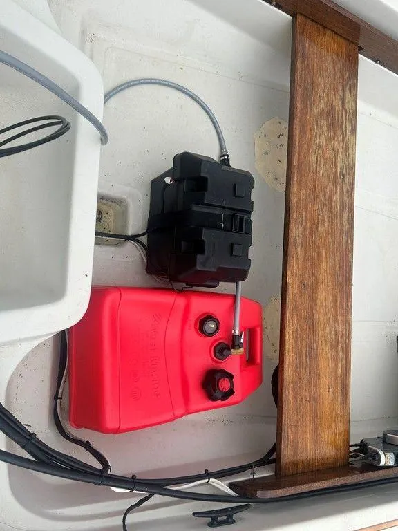 Slide: The Image of 1983 Boston Whaler Sport boat interior with red fuel tank and black battery box. - 19