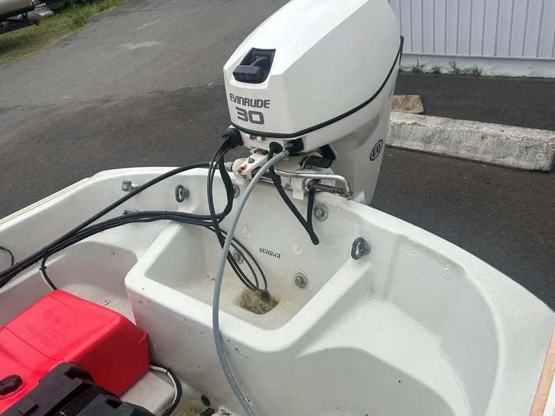Slide: The Image of 1983 Boston Whaler Sport boat with Evinrude 30 outboard motor, docked on pavement. - 4