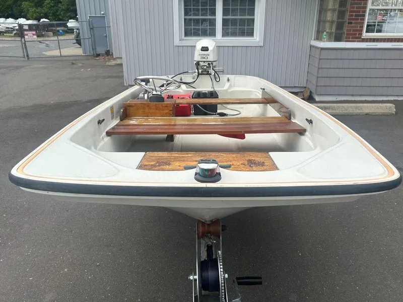 Slide: The Image of 1983 Boston Whaler Sport boat with outboard motor, parked on a trailer. - 5