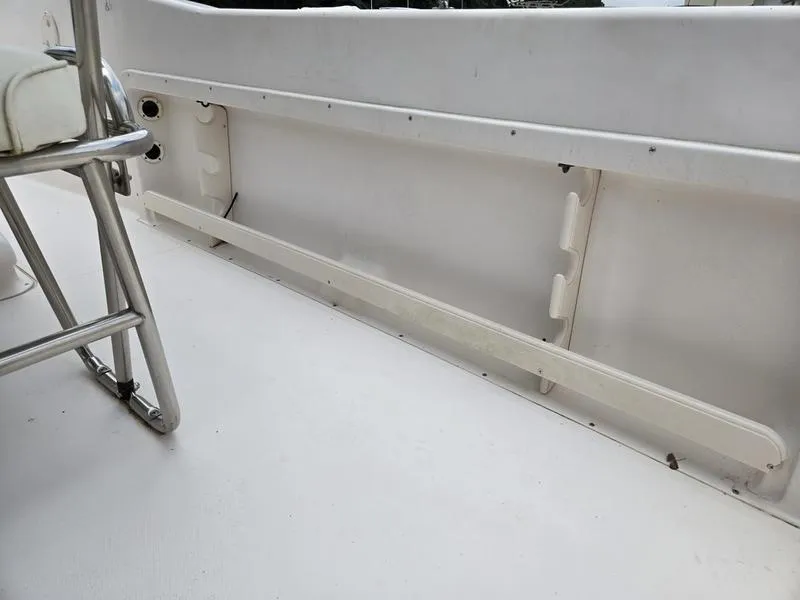 Slide: The Image of Interior of 2002 Grady-White 209 ESCAPE boat, featuring white seating and storage area. - 13