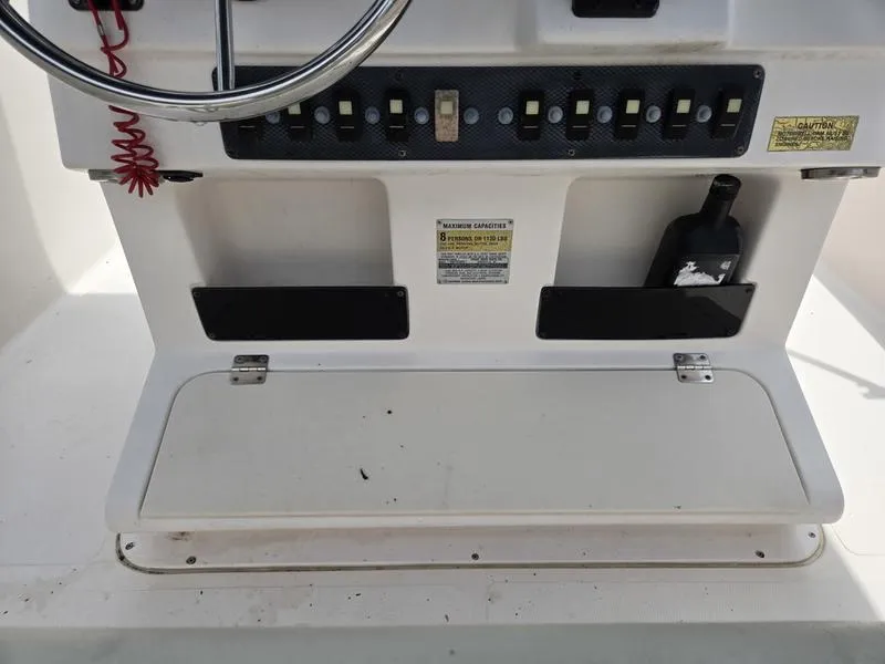 Slide: The Image of Console of 2002 Grady-White 209 ESCAPE boat with switches and storage compartments. - 14