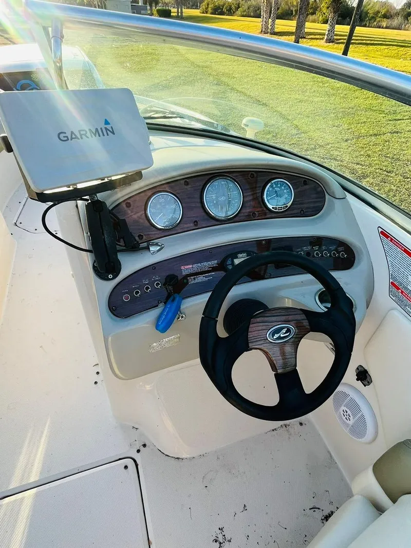 Slide: The Image of 2005 Sea Ray 240 Sundeck dashboard with Garmin GPS, steering wheel, and gauges. - 7