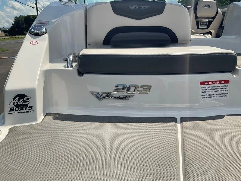 Slide: The Image of 2018 Chaparral 203 VR boat rear view with seating and safety warning. - 17