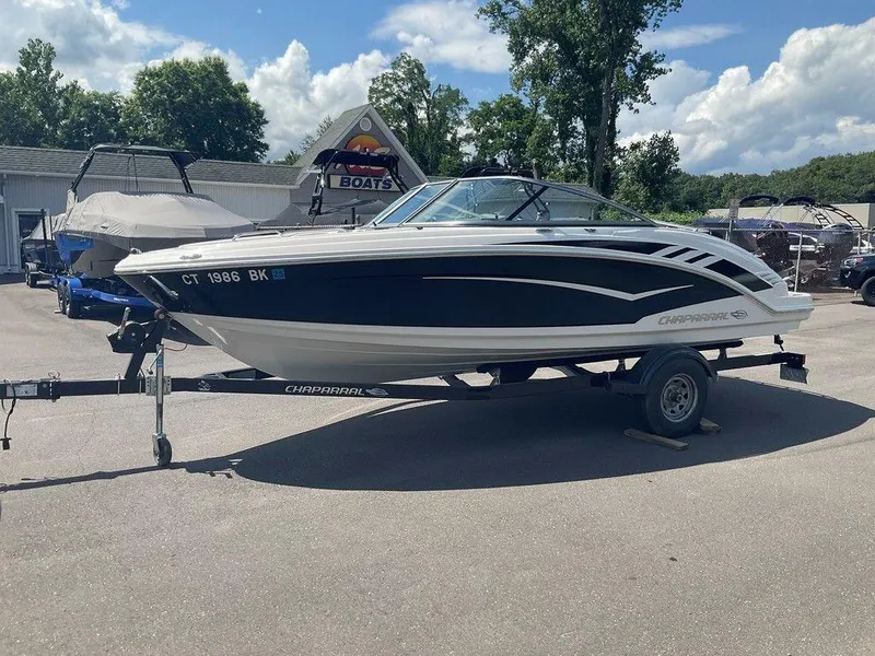 Slide: The Image of 2018 Chaparral 203 VR boat on trailer, parked outdoors under a clear sky. - 3