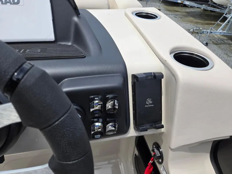 Slide: The Image of 2026 Harris Cruiser 230 dashboard with controls, cup holders, and AquaAmp device holder. - 19