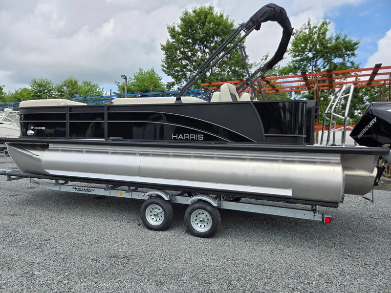Slide: The Image of 2026 Harris Cruiser 230 pontoon boat on trailer, parked outdoors. - 2