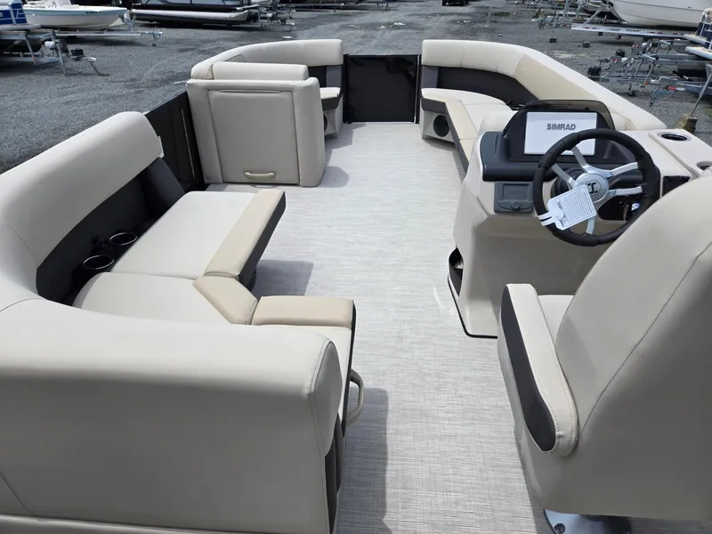 Slide: The Image of 2026 Harris Cruiser 230 pontoon boat interior with beige seating and steering console. - 29