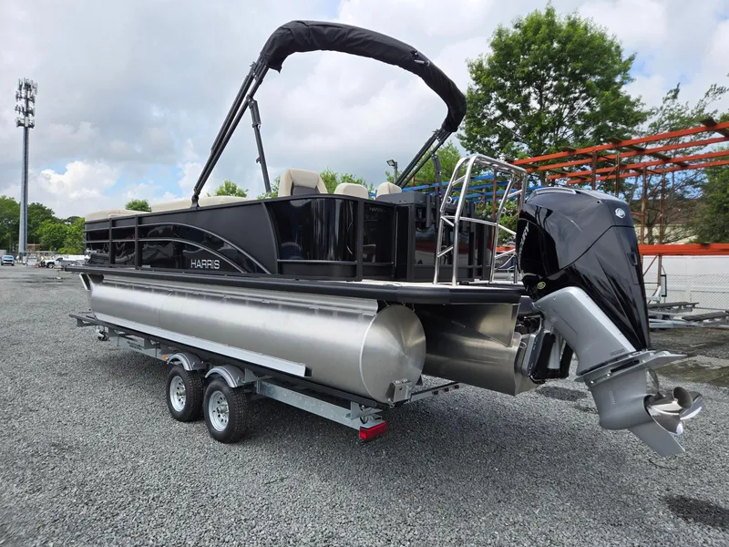 Slide: The Image of 2026 Harris Cruiser 230 pontoon boat on trailer, featuring sleek black design and powerful outboard motor. - 3