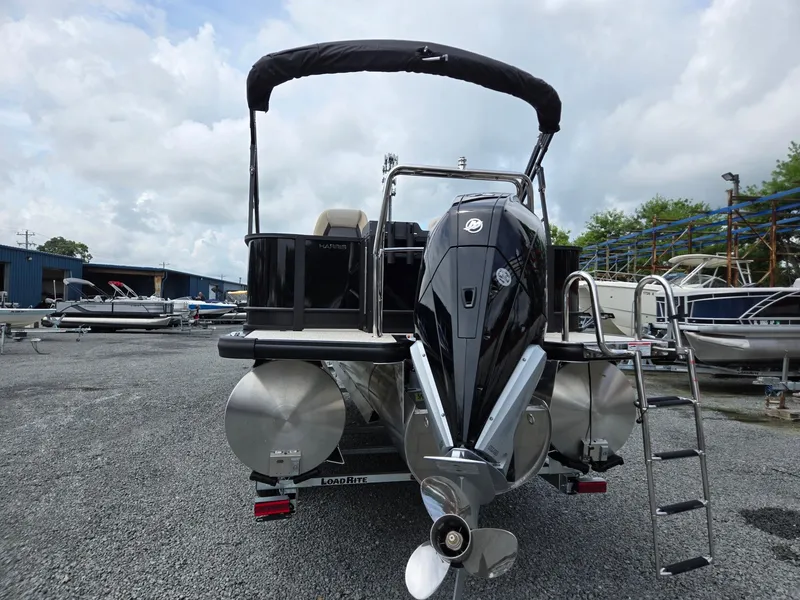 Slide: The Image of 2026 Harris Cruiser 230 pontoon boat with outboard motor, parked on gravel lot. - 4