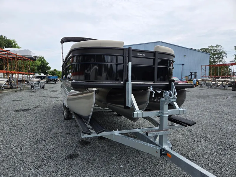 Slide: The Image of 2026 Harris Cruiser 230 pontoon boat on trailer in outdoor storage area. - 9