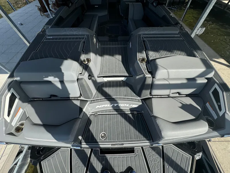 Slide: The Image of 2023 Nautique Super Air Nautique G25 Paragon boat interior with gray seating and deck. - 8