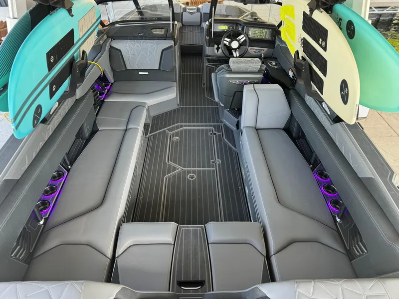 Slide: The Image of 2023 Nautique Super Air Nautique G25 Paragon interior with surfboards and luxury seating. - 9