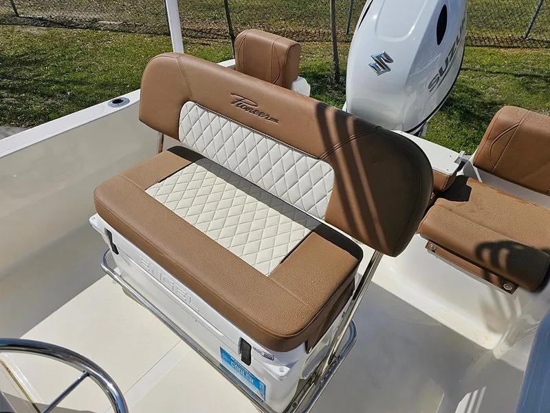 Slide: The Image of 2025 Pioneer 180 Islander boat interior with brown and white seating, Suzuki engine visible. - 11