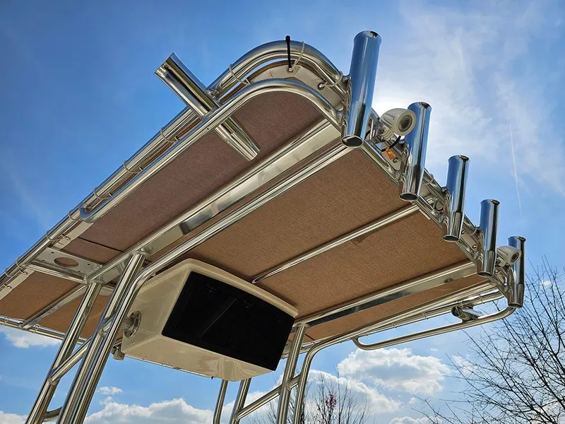 Slide: The Image of 2025 Pioneer 180 Islander boat T-top with rod holders against a clear blue sky. - 14