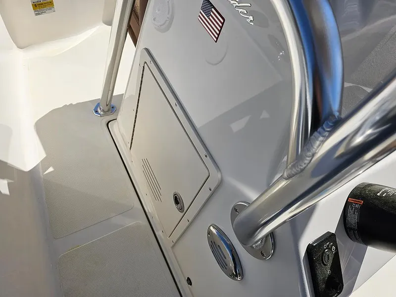 Slide: The Image of 2025 Pioneer 180 Islander boat interior with storage compartment and American flag detail. - 16