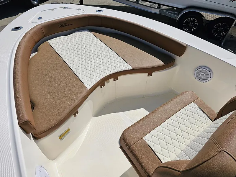 Slide: The Image of 2025 Pioneer 180 Islander boat interior with brown and white cushioned seating. - 18
