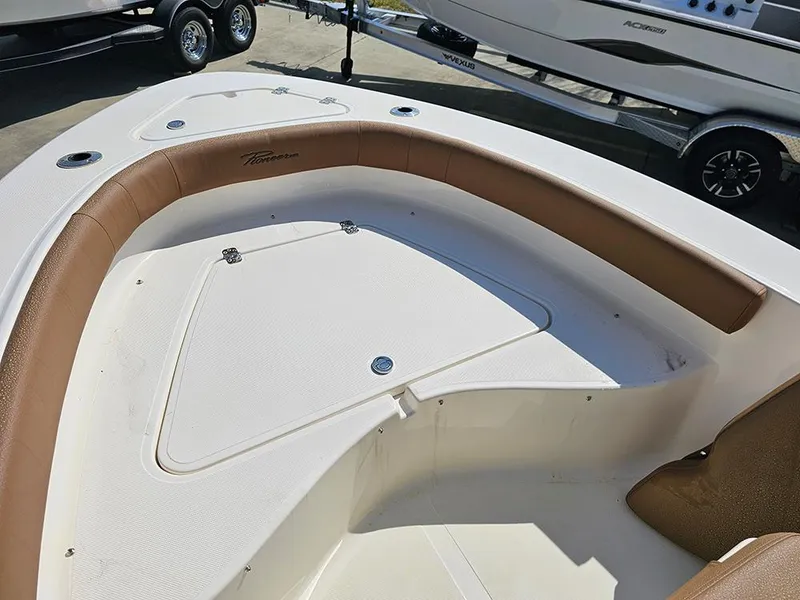 Slide: The Image of 2025 Pioneer 180 Islander boat interior with cushioned seating and storage compartments. - 19