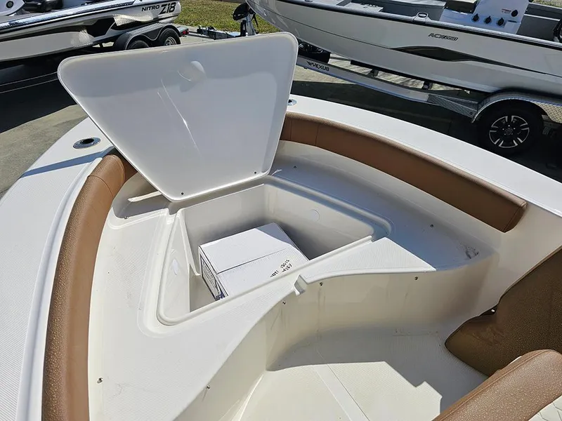 Slide: The Image of Open storage compartment on 2025 Pioneer 180 Islander boat, featuring brown seating and white interior. - 20