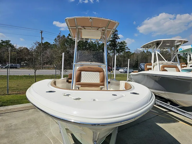 Slide: The Image of 2025 Pioneer 180 Islander boat with T-top, parked outdoors under blue sky. - 4