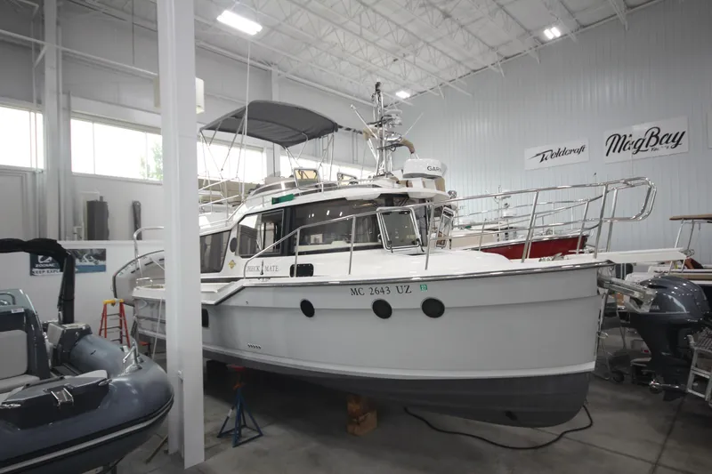 Slide: The Image of 2024 Ranger Tugs R-29 Command Bridge LE in showroom, side view. - 12