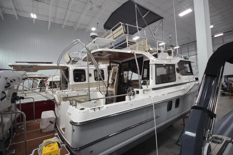 Slide: The Image of 2024 Ranger Tugs R-29 Command Bridge LE in a showroom, showcasing its sleek design and features. - 13