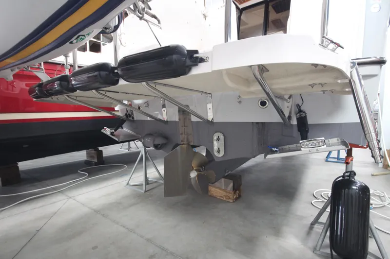 Slide: The Image of 2024 Ranger Tugs R-29 Command Bridge LE boat hull and propeller in a storage facility. - 17