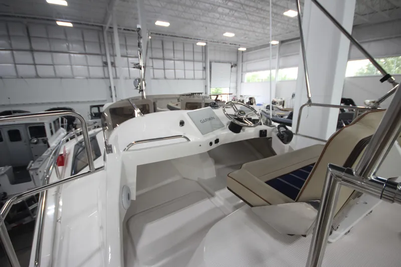 Slide: The Image of 2024 Ranger Tugs R-29 Command Bridge LE interior with helm and seating in a showroom. - 21