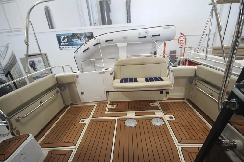 Slide: The Image of 2024 Ranger Tugs R-29 Command Bridge LE interior with teak flooring and cushioned seating. - 30