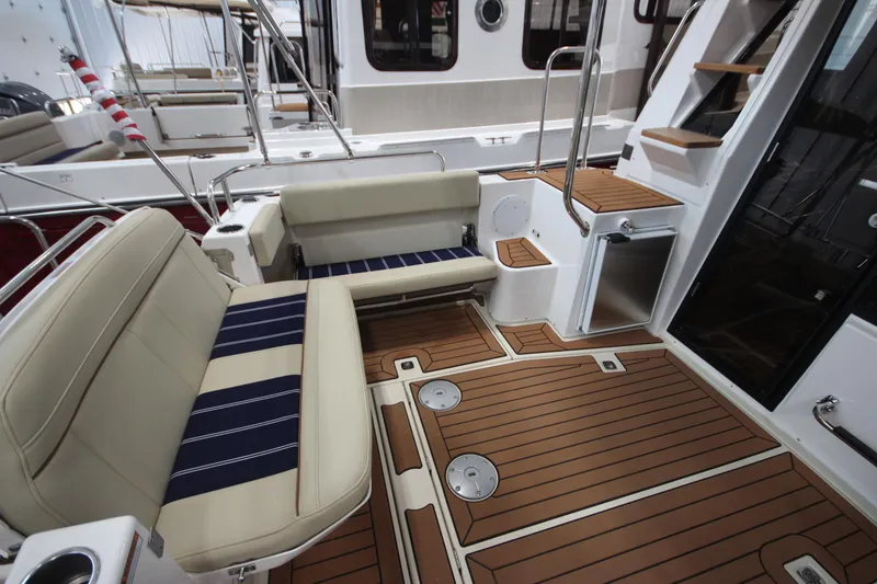 Slide: The Image of 2024 Ranger Tugs R-29 Command Bridge LE interior with seating and wood flooring. - 32