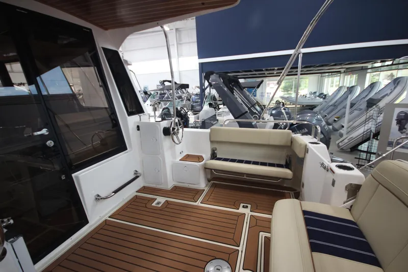 Slide: The Image of 2024 Ranger Tugs R-29 Command Bridge LE interior with seating and wood flooring. - 33