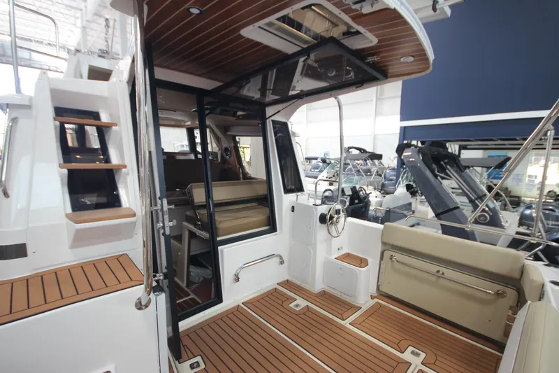 Slide: The Image of 2024 Ranger Tugs R-29 Command Bridge LE interior with wood accents and seating area. - 39