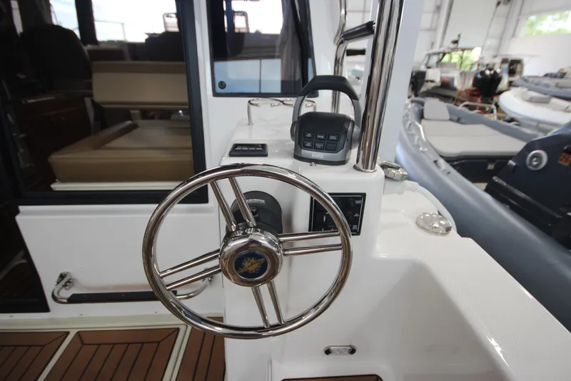 Slide: The Image of 2024 Ranger Tugs R-29 Command Bridge LE helm with stainless steel steering wheel. - 41