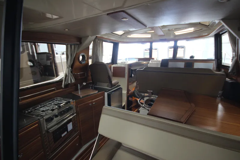 Slide: The Image of 2024 Ranger Tugs R-29 Command Bridge LE interior with modern kitchen and seating area. - 42