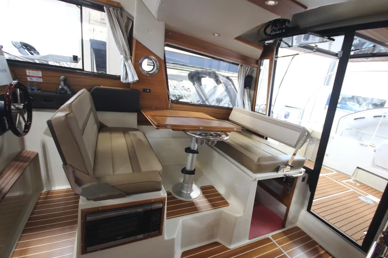 Slide: The Image of 2024 Ranger Tugs R-29 Command Bridge LE interior with seating and wooden accents. - 44