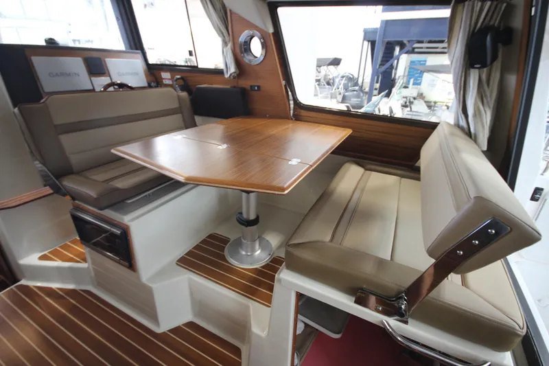 Slide: The Image of 2024 Ranger Tugs R-29 Command Bridge LE interior with dining area and cushioned seating. - 45