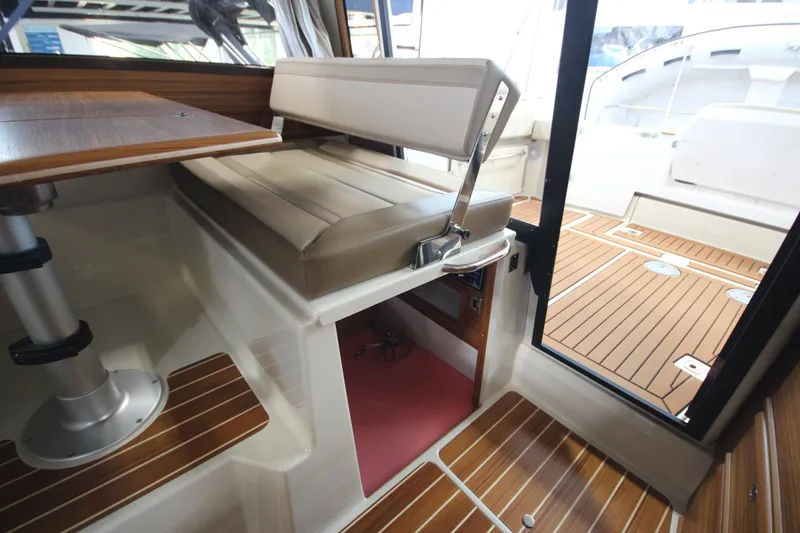 Slide: The Image of 2024 Ranger Tugs R-29 Command Bridge LE interior with wood accents and seating. - 46