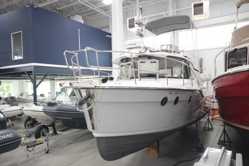 Slide: The Image of 2024 Ranger Tugs R-29 Command Bridge LE in showroom, surrounded by other boats. - 8