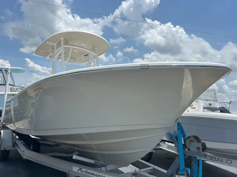 The Image of 2016 Sportsman Open 232 Center Console boat on trailer under blue sky. - 1